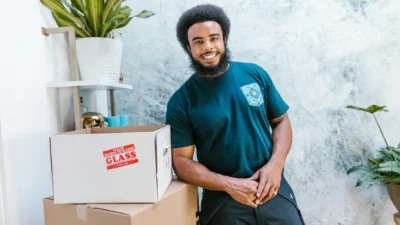 Person moving a potted houseplant to a sunny window for better light exposure.